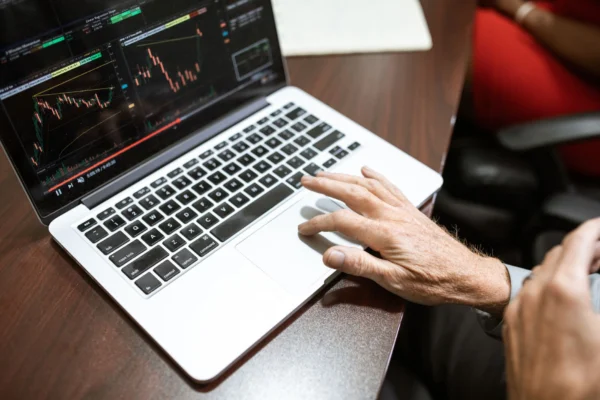 Como começar a investir: pessoa analisando gráficos de investimentos no notebook