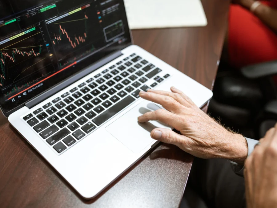 Como começar a investir: pessoa analisando gráficos de investimentos no notebook